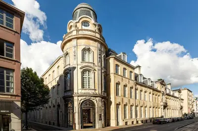 a large building with a tower on a street at Sapphire House Antwerp, Autograph Collection in Antwerp