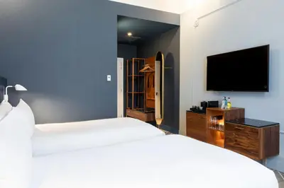 a bedroom with two beds and a flat screen tv at Sapphire House Antwerp, Autograph Collection in Antwerp