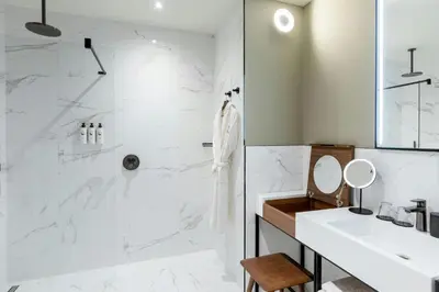 a white bathroom with a shower and a sink at Sapphire House Antwerp, Autograph Collection in Antwerp