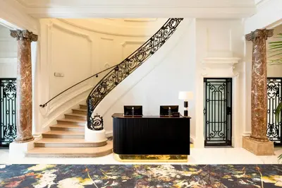 a lobby with a staircase with a table and chairs at Sapphire House Antwerp, Autograph Collection in Antwerp