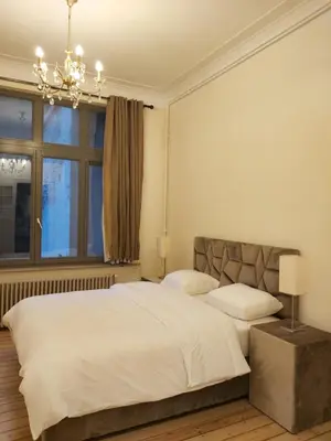 a bedroom with a large white bed and a window at Brussels 1904 in Brussels