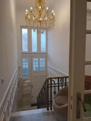 a chandelier in a hallway with a stairway at Brussels 1904 in Brussels