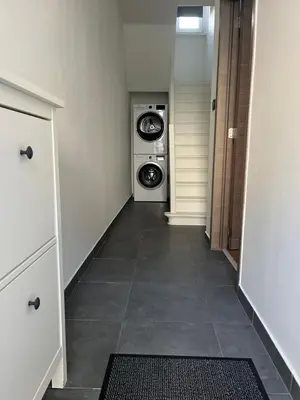 a hallway with a washer and dryer in a room at FDS Cosy House in Ghent