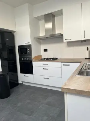 a kitchen with white cabinets and a stove top oven at FDS Cosy House in Ghent