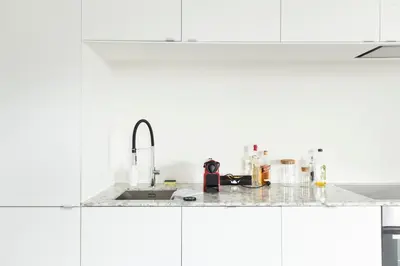a kitchen with white cabinets and a sink at Trendy Apartments as Base to Discover Ghent in Ghent