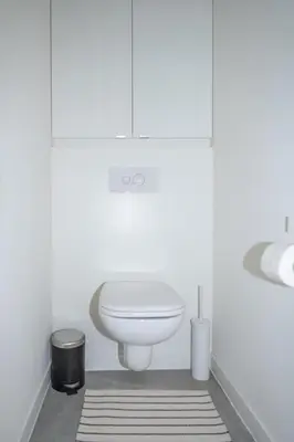 a white bathroom with a toilet and a sink at Trendy Apartments as Base to Discover Ghent in Ghent
