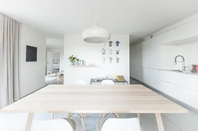 a white dining room with a table and chairs at Trendy Apartments as Base to Discover Ghent in Ghent
