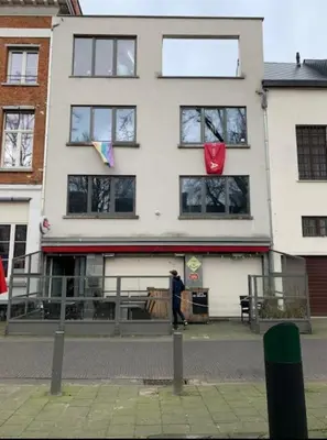 a man standing in front of a building at The Square - vacation rental with outdoor sauna - centre of Antwerp in Antwerp