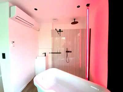 a pink bathroom with a tub and a shower at The Square - vacation rental with outdoor sauna - centre of Antwerp in Antwerp