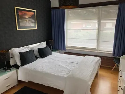 a bedroom with a white bed and two windows at Crea Els in Westerlo