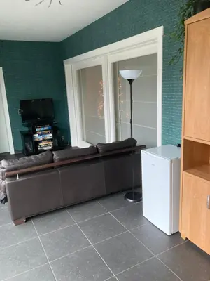 a living room with a couch and a window at Crea Els in Westerlo