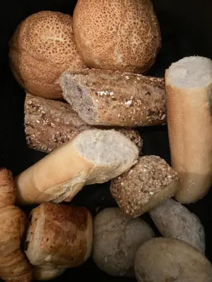 a pile of different types of bagels and bread at Crea Els in Westerlo