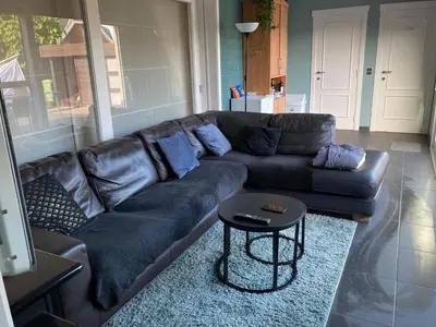 a leather couch in a living room with a table at Crea Els in Westerlo