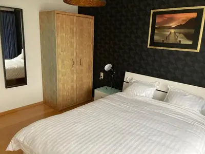 a bedroom with a large white bed and a cabinet at Crea Els in Westerlo