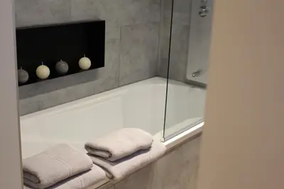 a bathroom with a shower with two towels on a bathtub at Maison Drappier in Ghent