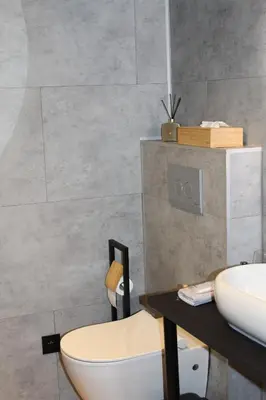 a bathroom with a white toilet and a sink at Maison Drappier in Ghent