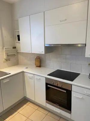 a kitchen with white cabinets and a stove top oven at Apartment de Kerk in Sint-Gillis-Waas