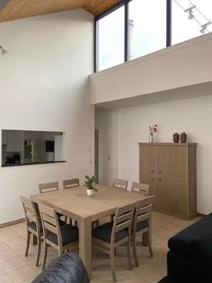 a dining room with a wooden table and chairs at Apartment de Kerk in Sint-Gillis-Waas