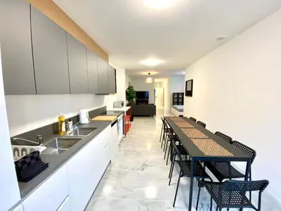 a kitchen with white cabinets and a table and chairs at Isabel Apartments in Antwerp