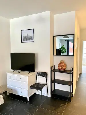 a room with a desk with a television and a chair at Isabel Apartments in Antwerp