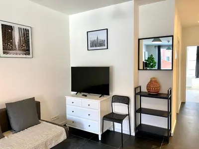 a bedroom with a bed and a tv and a chair at Isabel Apartments in Antwerp