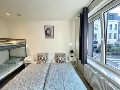 a bedroom with a bed and a large window at Isabel Apartments in Antwerp