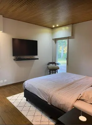 a bedroom with a large bed and a flat screen tv at Casa57 in Waasmunster