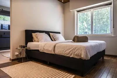 a large bed in a bedroom with a window at Casa57 in Waasmunster