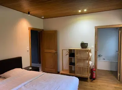 a bedroom with a bed and a bathroom with a tub at Casa57 in Waasmunster