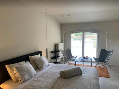 a bedroom with a bed with chairs and a table at Casa57 in Waasmunster