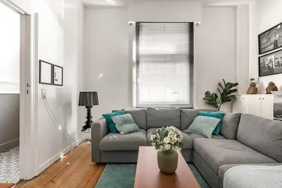 a living room with a gray couch and a table at Family Townhouse in the City Centre in Ghent