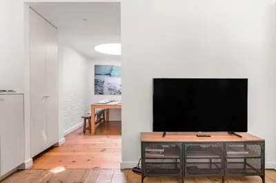a living room with a flat screen tv on a entertainment center at Family Townhouse in the City Centre in Ghent