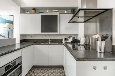 a kitchen with white cabinets and a sink at Family Townhouse in the City Centre in Ghent