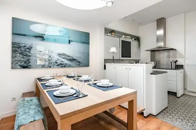 a dining room with a table and a kitchen at Family Townhouse in the City Centre in Ghent