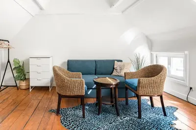 a living room with a blue couch and two chairs at Family Townhouse in the City Centre in Ghent