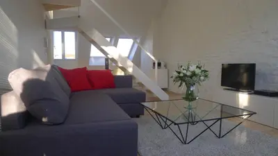a living room with a blue couch and a glass table at B&B Home & the City in Brussels