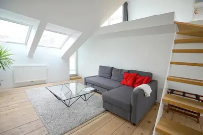 a living room with a couch and a glass table at B&B Home & the City in Brussels