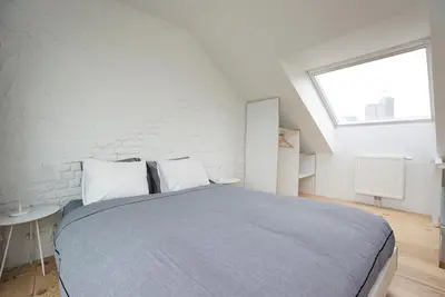 a bedroom with a large bed and a window at B&B Home & the City in Brussels