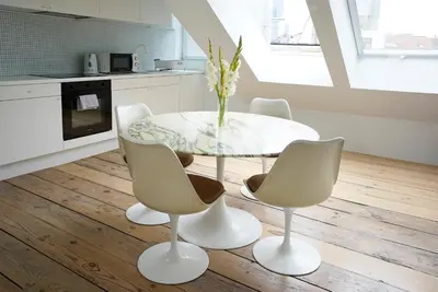 a white dining room with a glass table and chairs at B&B Home & the City in Brussels