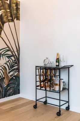 a black cart with glasses and a bottle of wine at Beautiful appartment in the heart of Antwerp in Antwerp