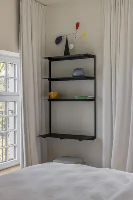 a bedroom with a bed and a black shelf at Hotel Nenuphar in Ghent