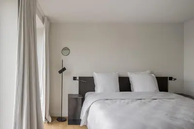 a white bed with white sheets and pillows at Hotel Nenuphar in Ghent