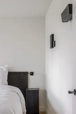 a bedroom with a white bed with a wooden headboard at Hotel Nenuphar in Ghent