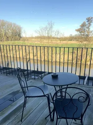 a table and chairs on a porch with a view of a field at Hotel Nenuphar in Ghent