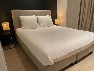 a large bed with white sheets and pillows at Casa Clementina - 3 Bedroom Apartment in a Art-Nouveau House in Ghent