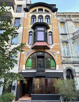 a large brick building with a balcony on it at Casa Clementina - 3 Bedroom Apartment in a Art-Nouveau House in Ghent