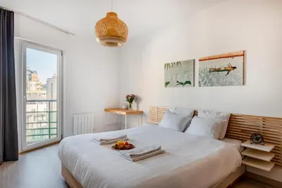 a white bedroom with a large bed with a bowl of fruit on it at Royal Design Residence in Brussels