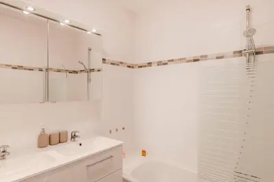 a white bathroom with a tub and a sink at Royal Design Residence in Brussels
