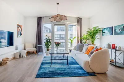 a living room with a couch and a blue rug at Royal Design Residence in Brussels