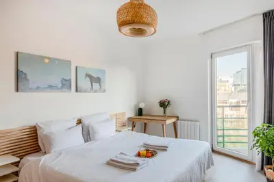 a white bedroom with a bed with a bowl of fruit on it at Royal Design Residence in Brussels